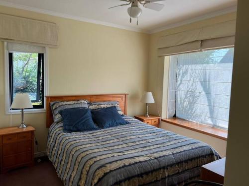 康塞普西翁Acogedora casa en Pingueral的一间卧室配有一张带蓝色枕头的床和一扇窗户。