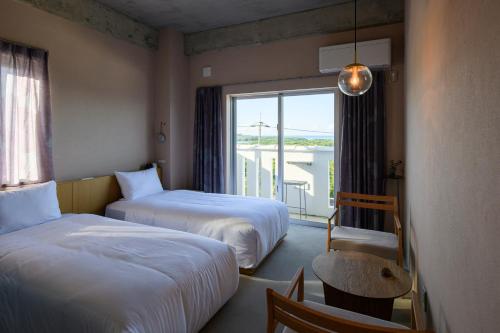 石垣岛MEGURU l 巡的酒店客房设有两张床和窗户。