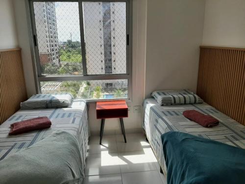 马瑙斯Apartamento completo的两张床位于带窗户的房间内