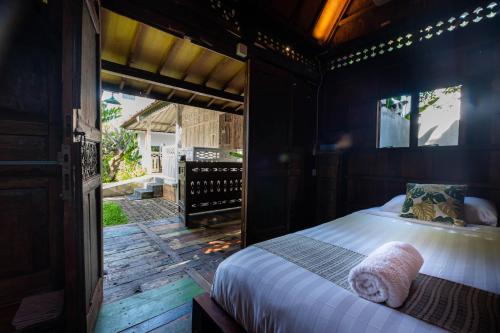 乌布Kubu Kirana by Supala的一间卧室,在木甲板上配有一张床