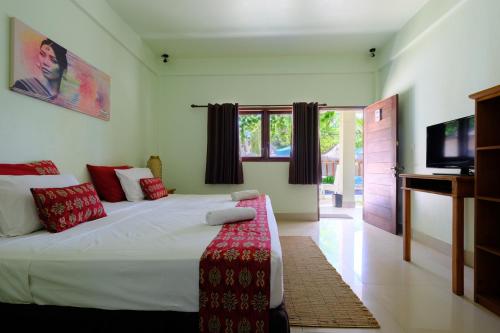 吉利特拉旺安旺安尼尔瓦纳酒店的一间卧室配有一张大床和电视