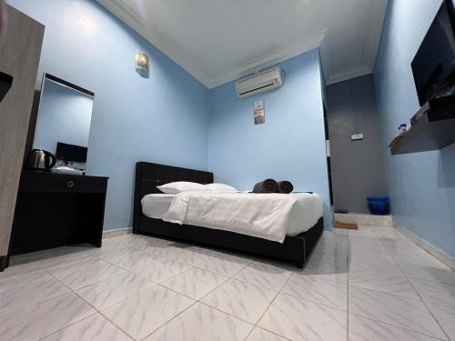 克提HOTEL RAUDHAH Kerteh的一间设有一张蓝色墙壁床铺的卧室