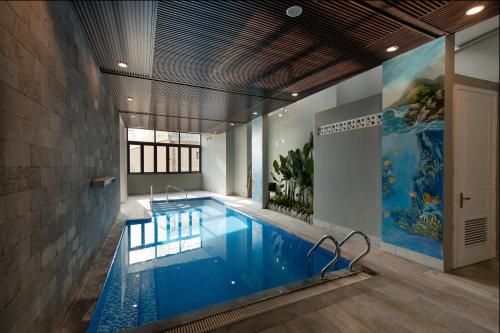 岘港Mercury Beach DaNang的游泳池位于带大型游泳池的客房内