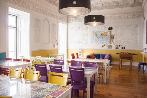 里斯本丽斯比昂旅馆的一间带桌椅的餐厅和一间黄色墙壁的房间