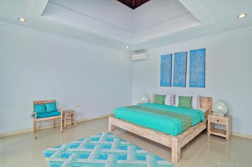 沙努尔阿拉姆比鲁别墅的卧室配有1张床、1张桌子和1把椅子