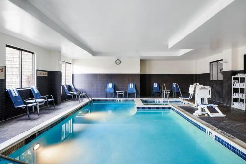 哈里斯堡赫氏哈里斯堡万豪广场套房酒店的大楼内带蓝色椅子的游泳池
