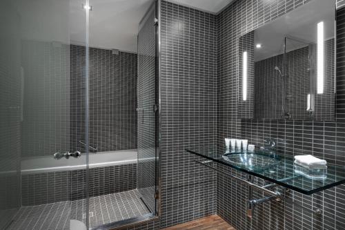 米兰米兰万豪AC酒店的一间带玻璃淋浴和水槽的浴室