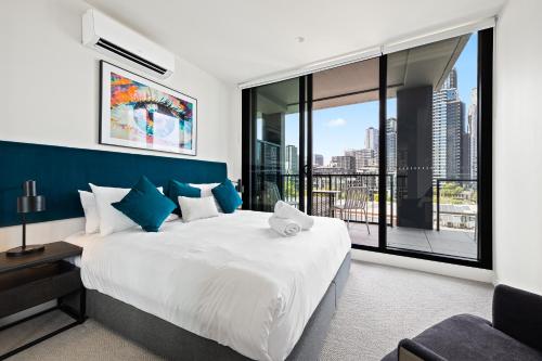 墨尔本The Marker Apartments Melbourne的一间卧室设有一张大床和一个大窗户