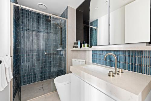 墨尔本The Marker Apartments Melbourne的浴室设有水槽、卫生间和蓝色瓷砖。