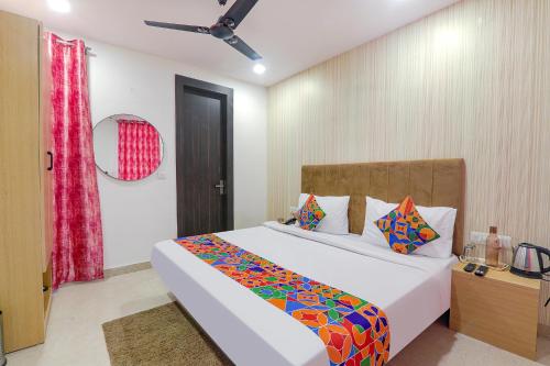 PrayagrajFabHotel The Comfort的一间卧室配有一张大床和色彩缤纷的毯子