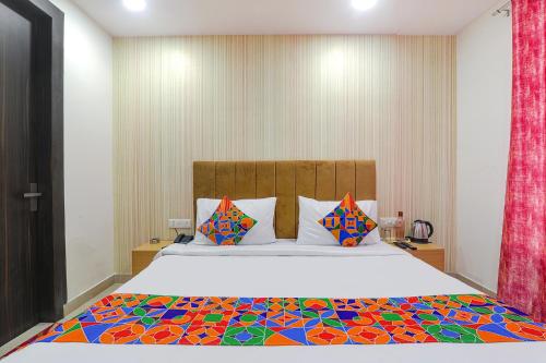 PrayagrajFabHotel The Comfort的一间卧室配有一张大床和色彩缤纷的被子