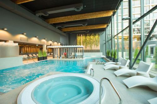 尤尔马拉优马拉温泉酒店的大楼内带热水浴池的大型游泳池