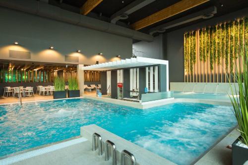 尤尔马拉优马拉温泉酒店的一座大型游泳池,位于一座带大型游泳池的建筑内