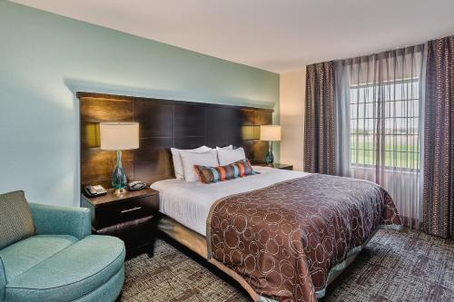 俾斯麦俾斯麦套房酒店的配有一张床和一把椅子的酒店客房