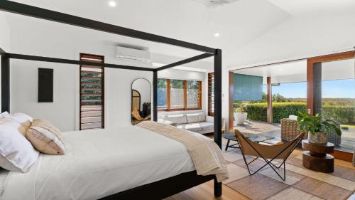 拜伦湾Cape Vue Byron的一间带大床的卧室和一间客厅