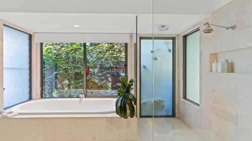 拜伦湾Cape Vue Studio 4的带浴缸的浴室和窗户。