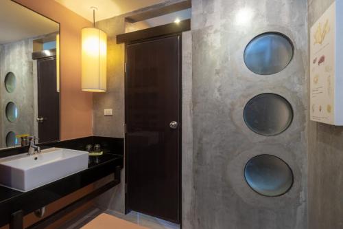 华欣Sila at Hua Hin Serviced Apartment & Hotel的一间带水槽和镜子的浴室
