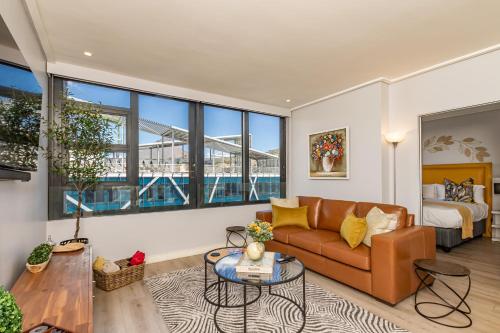 开普敦Beautiful Family Apartment with amazing views @ 16 on Bree的带沙发、床和窗户的客厅