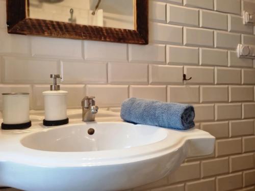 拉普斯尼恩Miodowa Chata的白色浴室水槽和蓝色毛巾