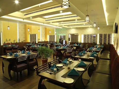 蒂鲁帕蒂Renest Tirupati的一间配备有桌椅及蓝餐巾的用餐室