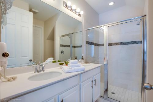 奥兰多Solara Resort - 5 Bed 4,5 Baths TOWNHOME的白色的浴室设有水槽和淋浴。