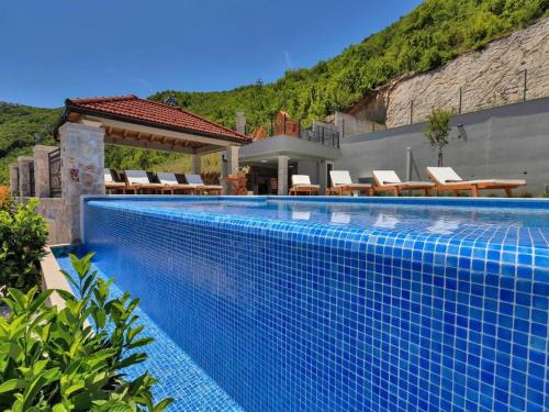 StudenciVilla Finca Lazeta的一个带椅子的蓝色游泳池以及一座房子