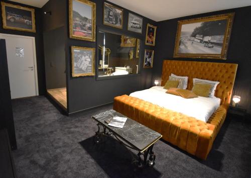 斯帕Luxury Spa Hotel - Automobile的一间卧室配有一张床、一张沙发和一面镜子