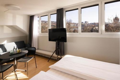 苏黎世Fred Hotel Zürich Hauptbahnhof的一间卧室设有一张床、一台电视和窗户。
