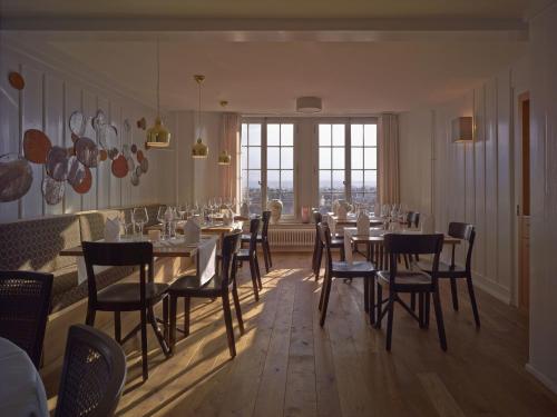 图恩施罗斯堡精品酒店 的一间带桌椅的用餐室和窗户。