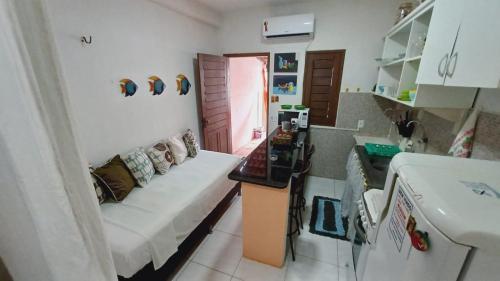 特赖里Casinha guagiru的客厅设有白色沙发,厨房设有