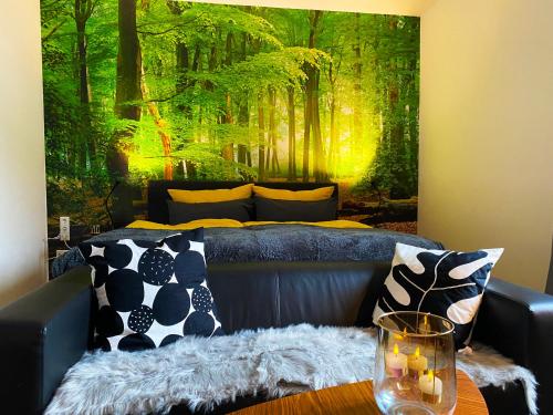 比勒费尔德Wood-Appartement的带沙发和森林壁画的客厅