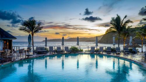 古斯塔维亚Hotel Manapany的一个带椅子的游泳池,背景是大海