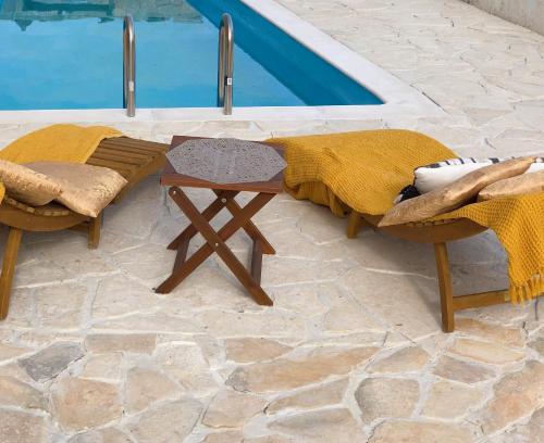 德拉格MiaBella Resort的游泳池畔的一张桌子和两把椅子