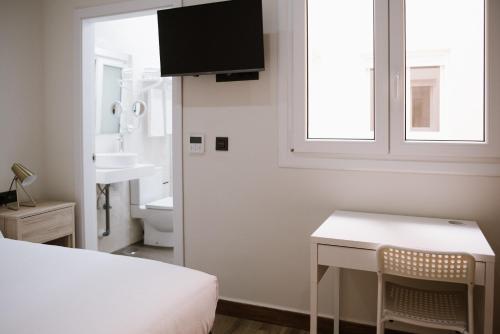 梅利利亚Melilla Centro Hotel ***的一间卧室配有一张床、一张桌子和一个水槽