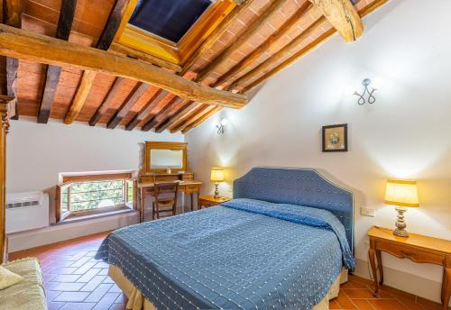 圣米尼亚托Borgo Bucciano的一间设有蓝色床的卧室,位于一个拥有木制天花板的房间