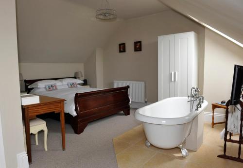 滨海绍森德苏恩诺斯旅馆的一间卧室配有一张床、一个浴缸和一个浴缸