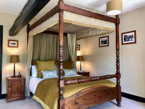 LoweswaterKirkstile Inn的一间卧室配有一张木天蓬床。