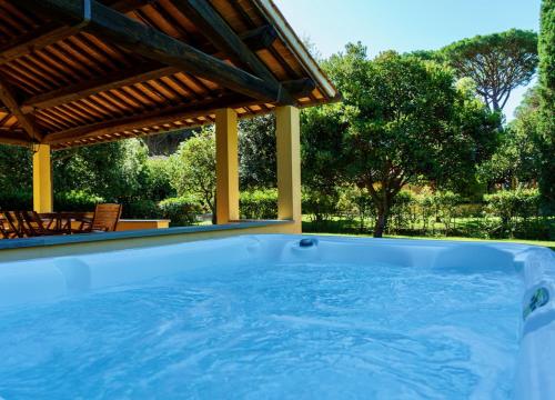 圣温琴佐Ville Di Villa Biserno的后院的热水浴池,带凉棚
