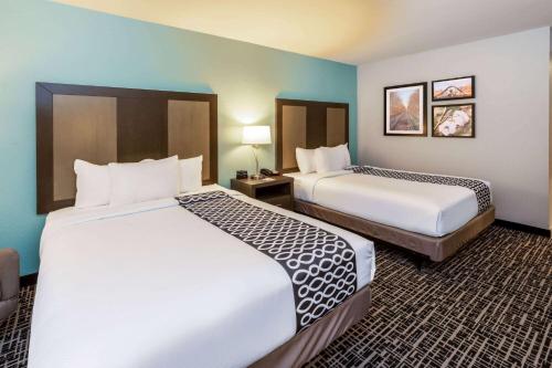 琼斯伯勒La Quinta by Wyndham Jonesboro的酒店客房,设有两张床和两张桌子