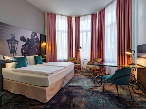 汉诺威美居汉诺威城市酒店的配有一张床和一张书桌的酒店客房
