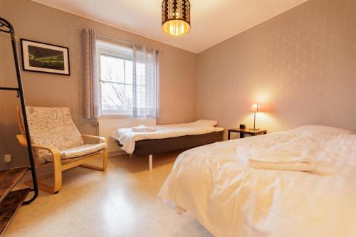 阿比斯库Lovely house in Abisko的一间卧室设有两张床、一把椅子和一个窗户。