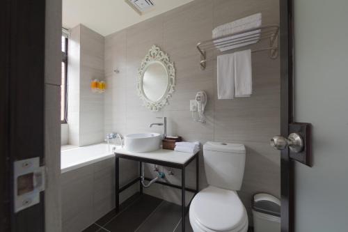 基隆香草艺术旅店的一间带卫生间、水槽和镜子的浴室