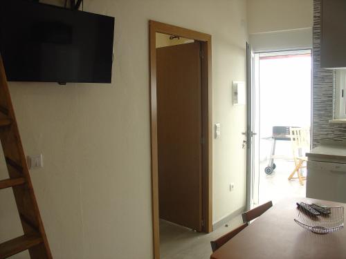 蒙蒂戈杜Casa Verão Azul的一间设有门、桌子和电视的房间