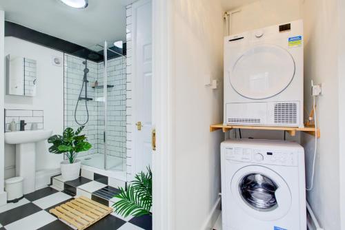 伦敦Statera Apartments - 2-Bed House in Stratford的洗衣房配有洗衣机、烘干机和淋浴
