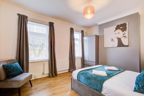 伦敦Statera Apartments - 2-Bed House in Stratford的卧室配有床、椅子和窗户。