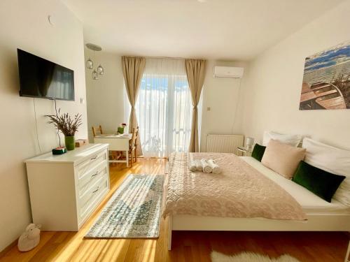 凯斯特海伊Libás Apartman的一间卧室配有带梳妆台和窗户的床。