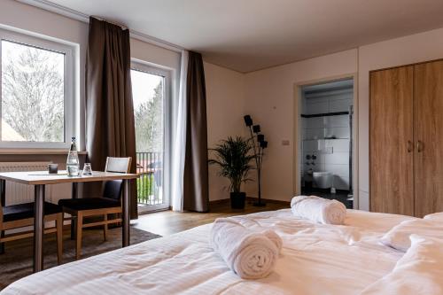 万德利茨Motel Zur Dachsbaude的一间卧室配有一张床、一张桌子和一张桌子