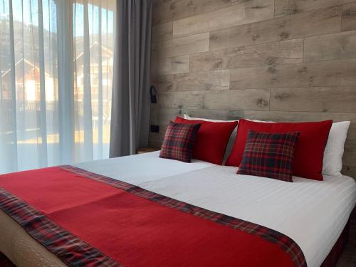 博尔米奥Al Bait Ross的一张带红色枕头和砖墙的大床