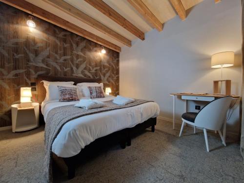 伊芙尔莱韦克Domaine de l'Epau Eco-Resort - Eco-Lodges的一间卧室配有一张床、一张桌子和一把椅子