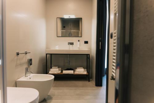 莱切Arryvo Hotel的一间带水槽、卫生间和镜子的浴室